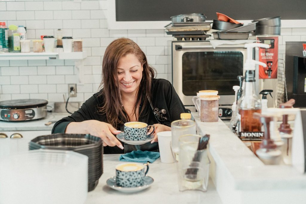 A woman making coffee in a café kitchen