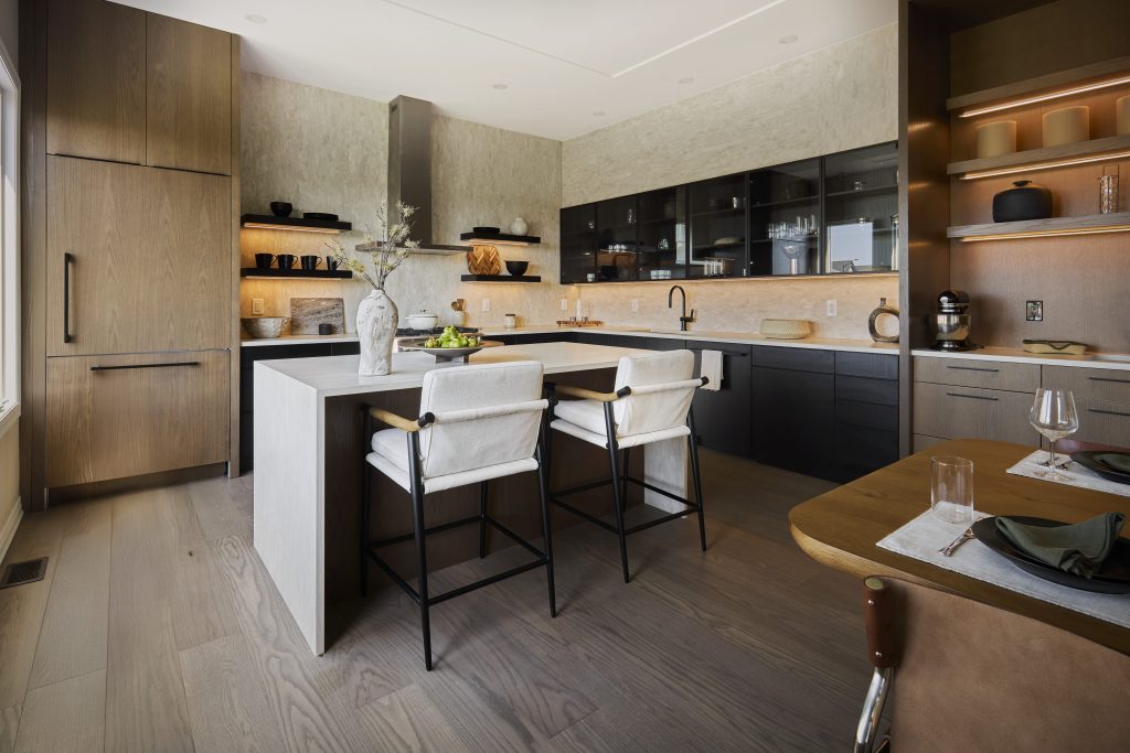 The Ironridge model home: kitchen with pale oak cabinetry and a white island with bar stools