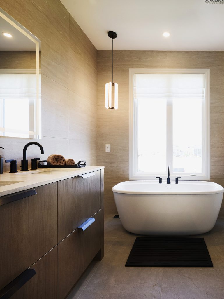 The Stonehaven Loft model home: ensuite with a freestanding tub and dark vanity