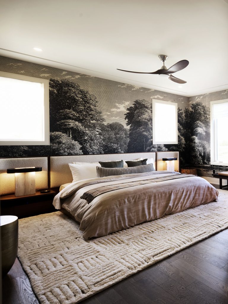The Stonehaven Loft model home: primary bedroom with a mural wall and ceiling fan