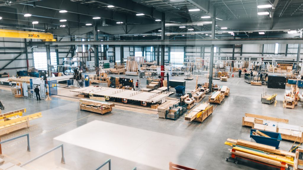 Caivan's manufacturing plant, with assembly lines and stacked timber