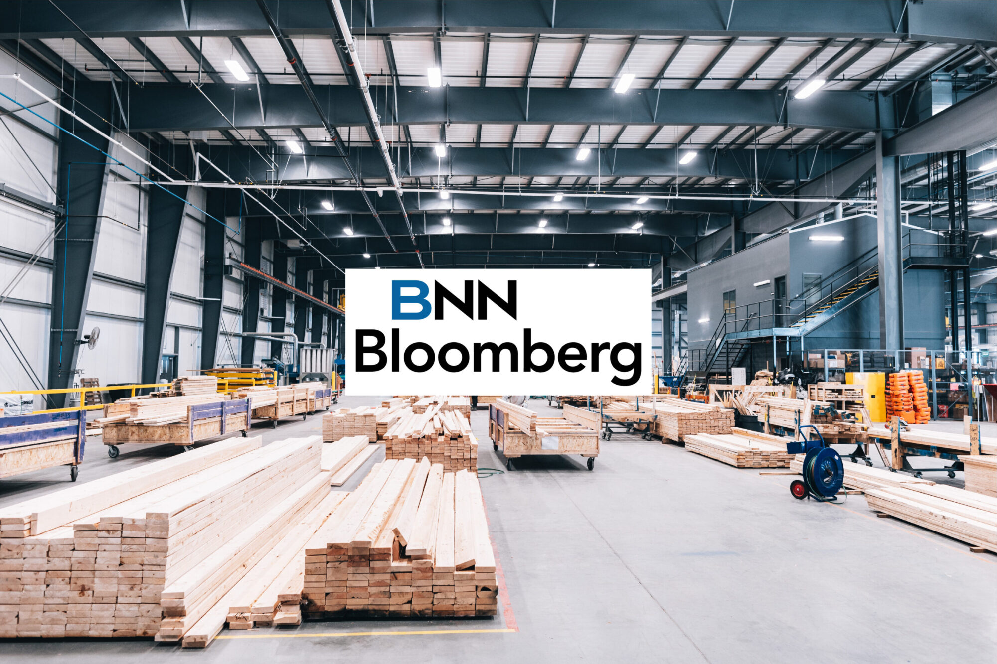 The BNN Bloomberg logo over Caivan's factory floor and stacked lumber