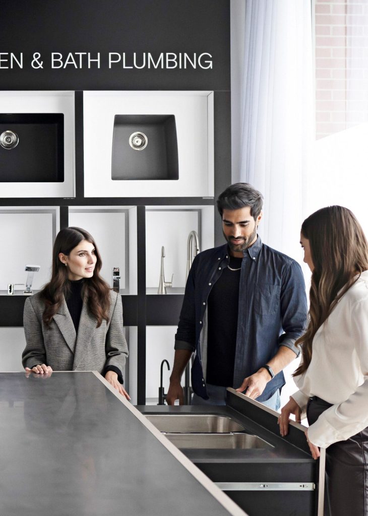 A design consultant showing two customers a sink and tap display in the Design Studio