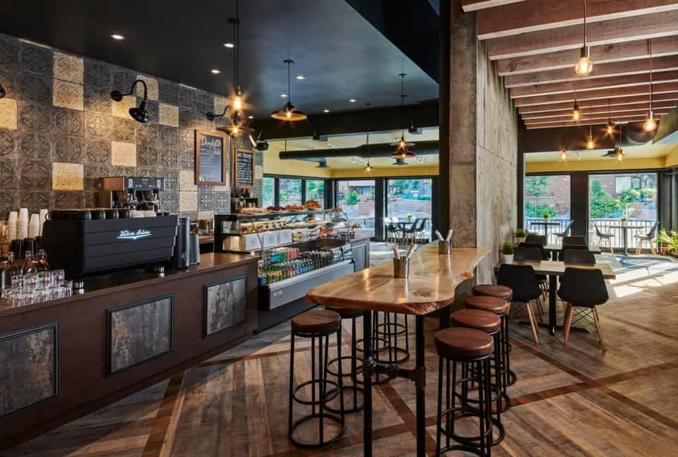 Interior of a café bar, with high stools, pendant lights and a tiled counter