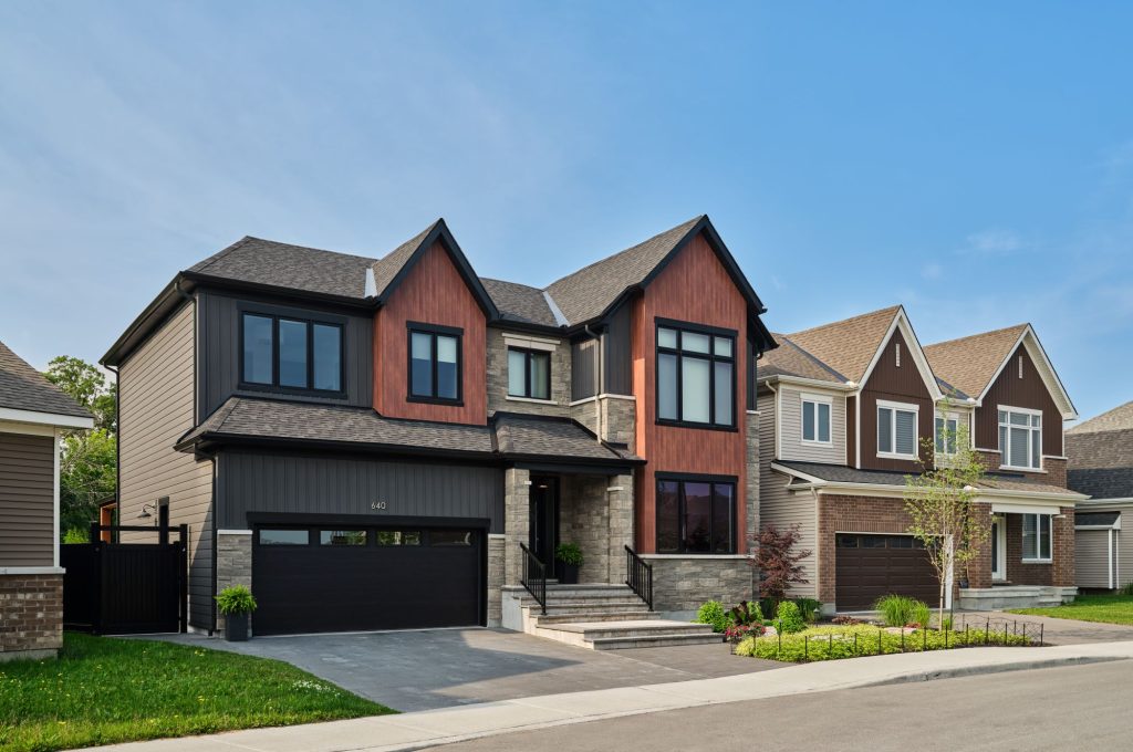 Finished Caivan homes at The Conservancy, in red brick and grey siding with double garages