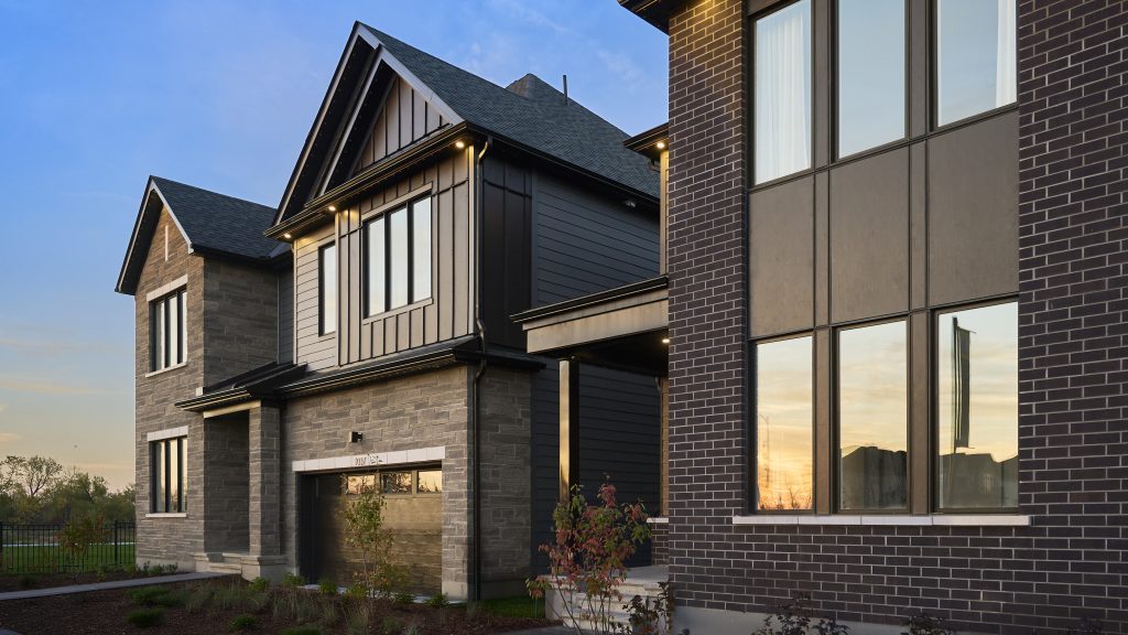 Exterior of a Caivan home at The Conservancy at dusk, in stone and dark siding