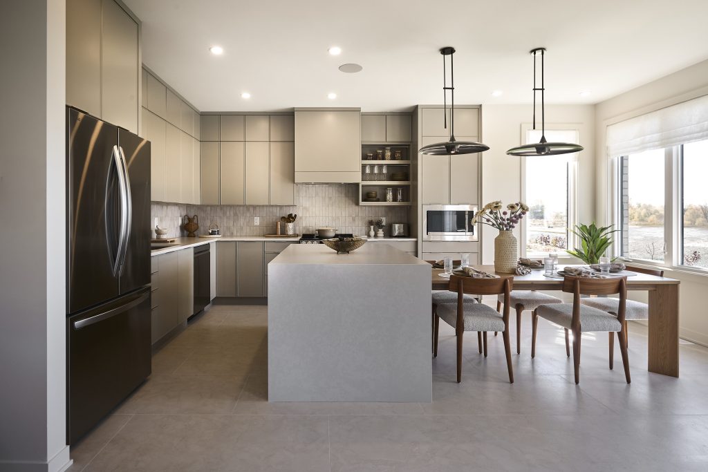 The Hemlock model home: grey kitchen with an island, pendant lights and a dining table beyond