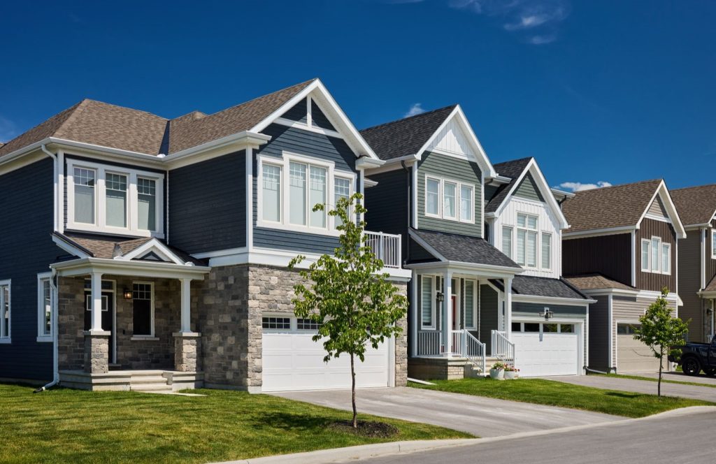 Street of finished Fox Run homes in blue and grey siding with stone bases