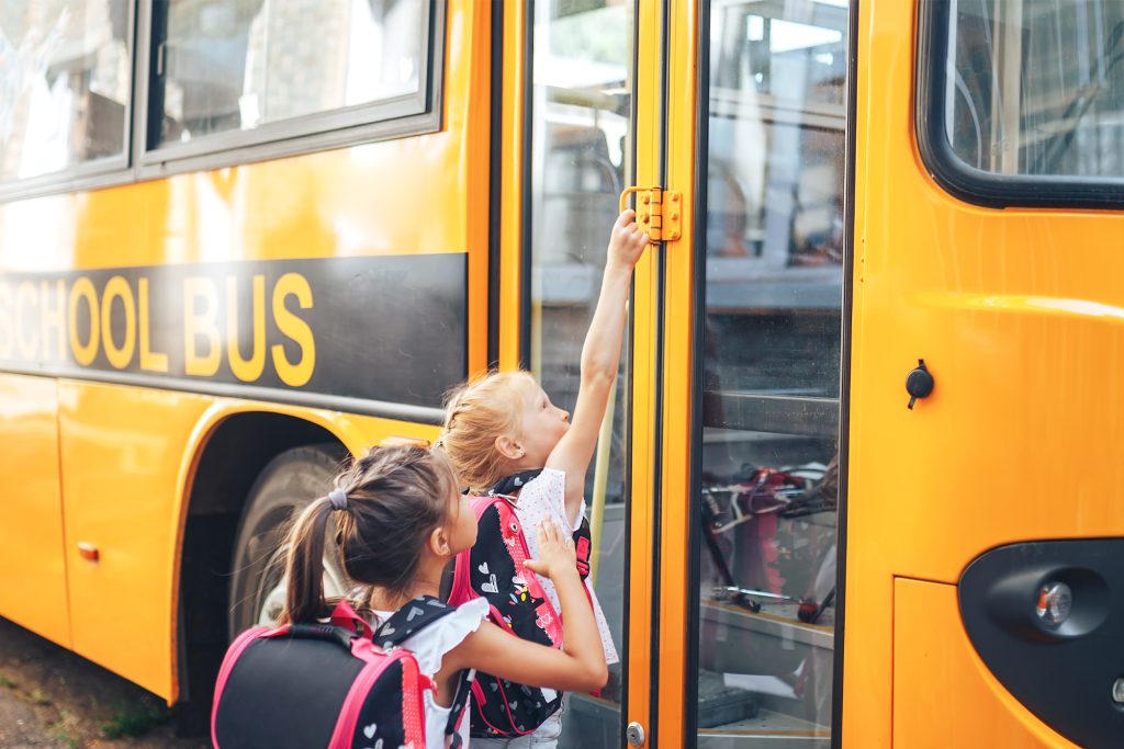 Two children boarding a school bus