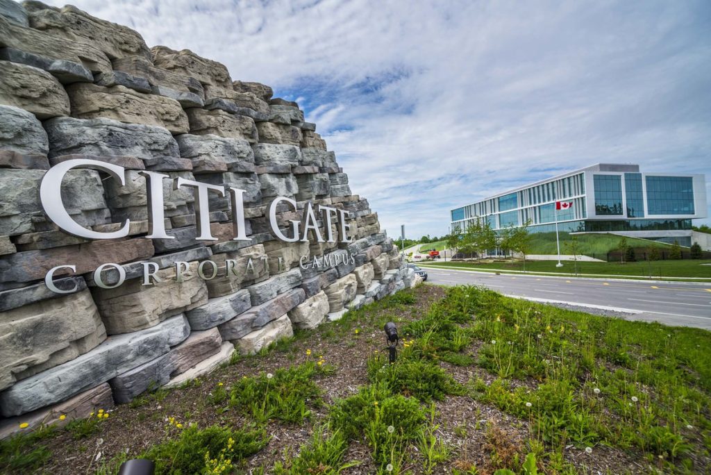 The stone entrance sign to the Citigate corporate campus, with office buildings behind