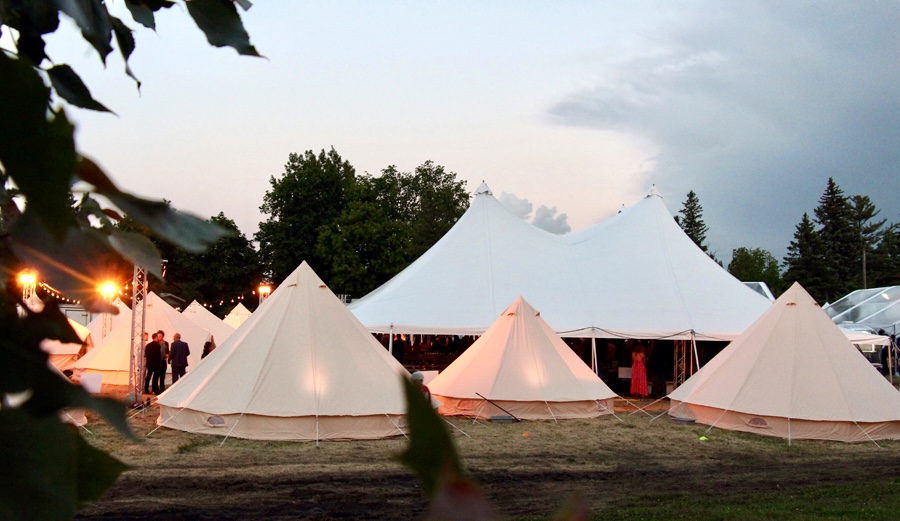 Marquee tents lit at dusk for an outdoor evening event