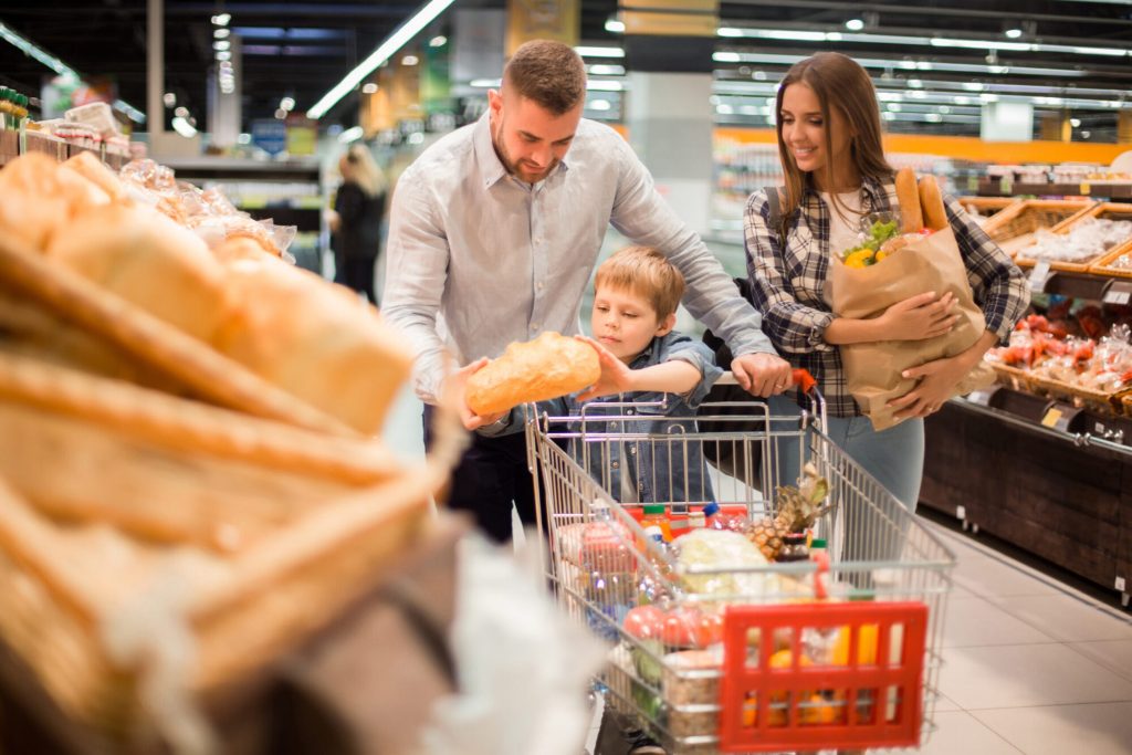 A family shopping for groceries in a supermarket aisle